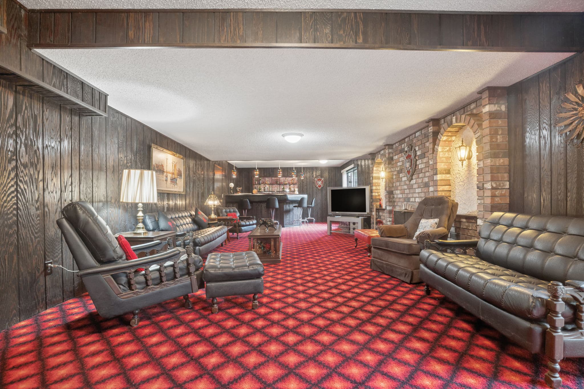 Retro walk-out basement rec room with wet bar and brick archways
