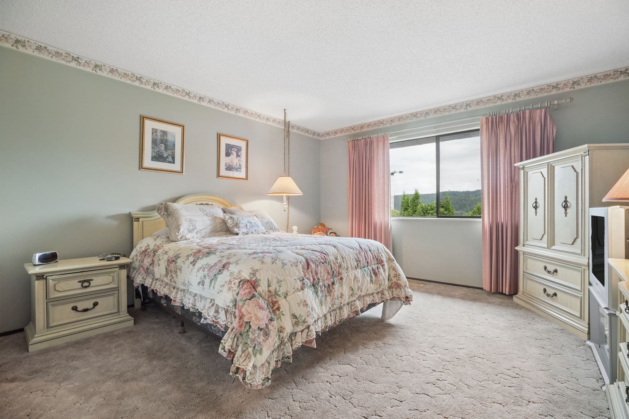 Primary bedroom with a view toward the trees and mountains