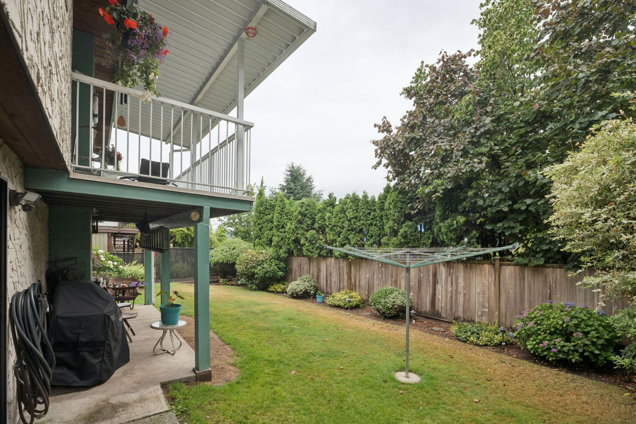 Covered patio under the deck, opening onto the fenced backyard
