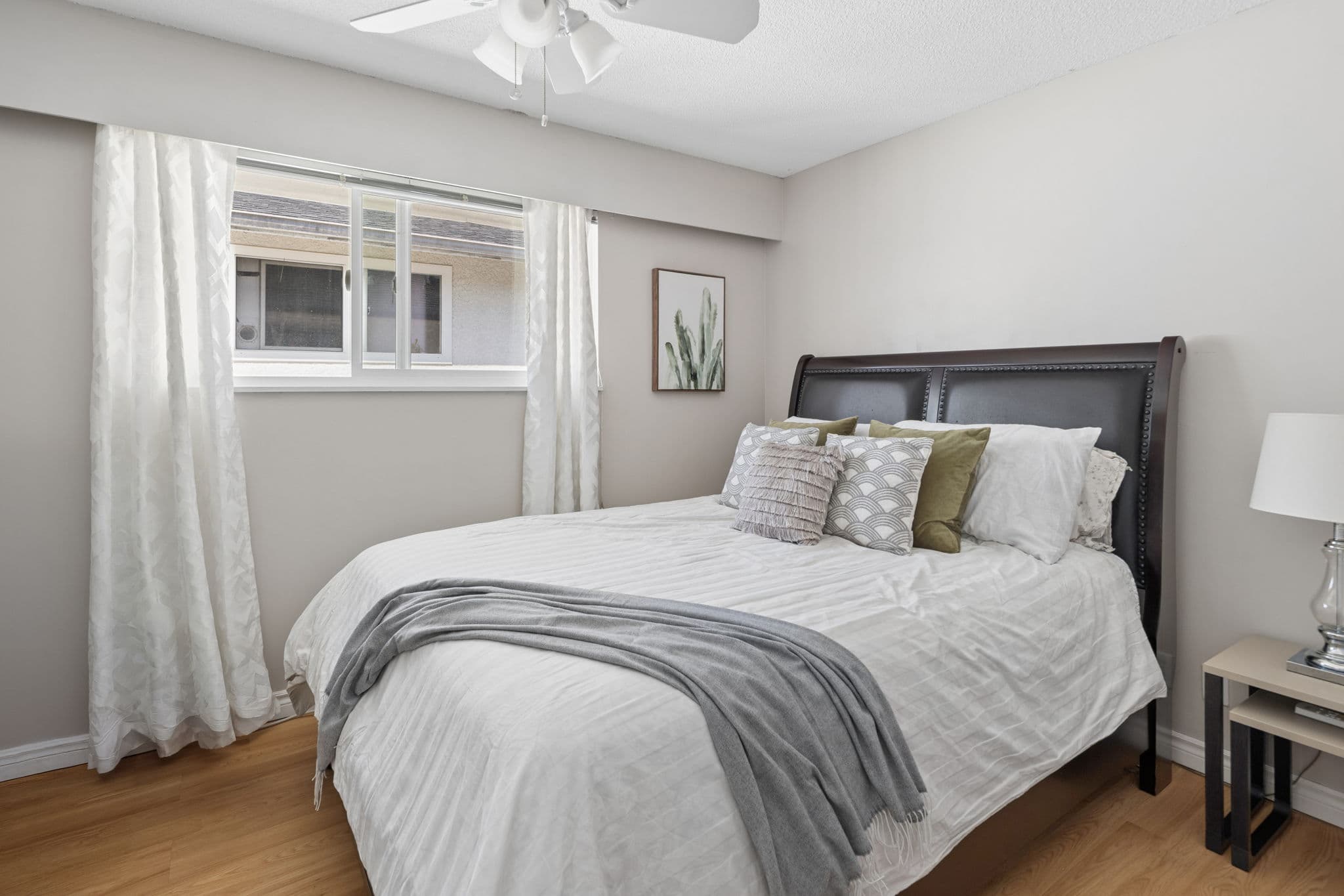 Primary bedroom with large window and ceiling fan